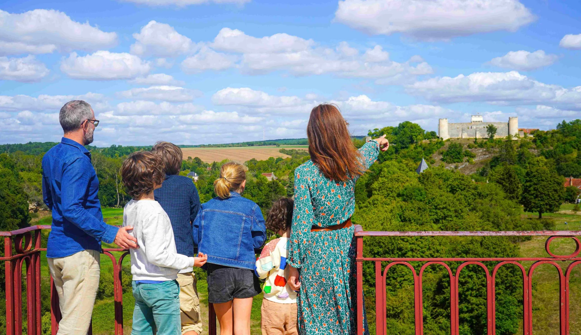 The view of the Château de Druyes-les-Belles-Fontaines from the viaduct for a family of vacationers