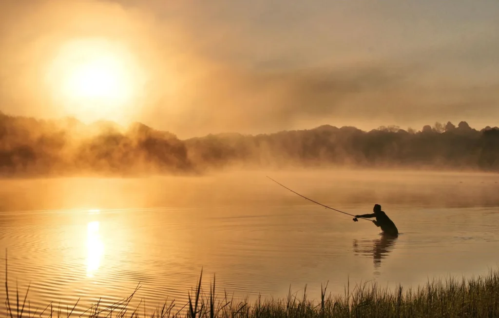 A fisherman in action in the water of the lake