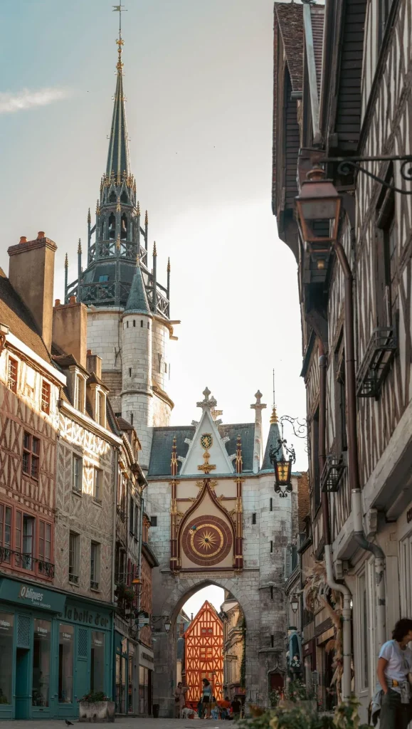 La Tour de l'Horloge au centre-ville d'Auxerre entouré par des maisons à pan de bois colorées.