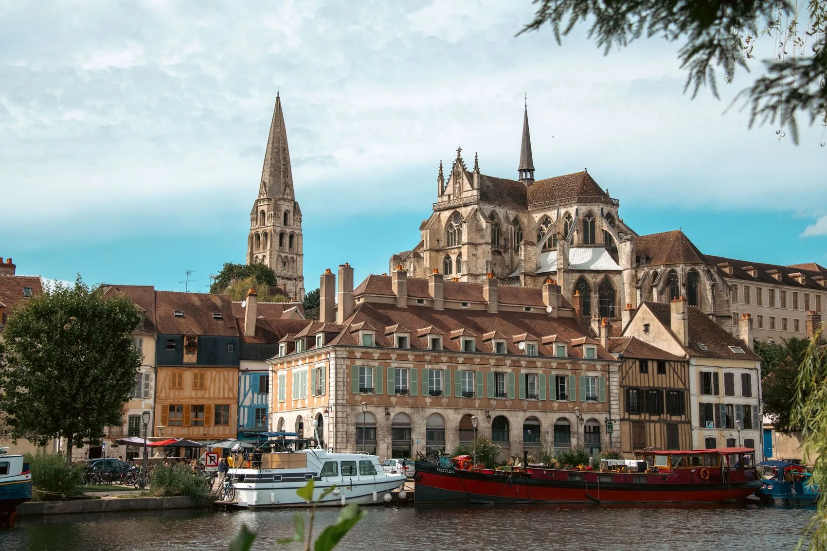View of Saint-Germain Abbey from the quays with barges and timber-framed houses