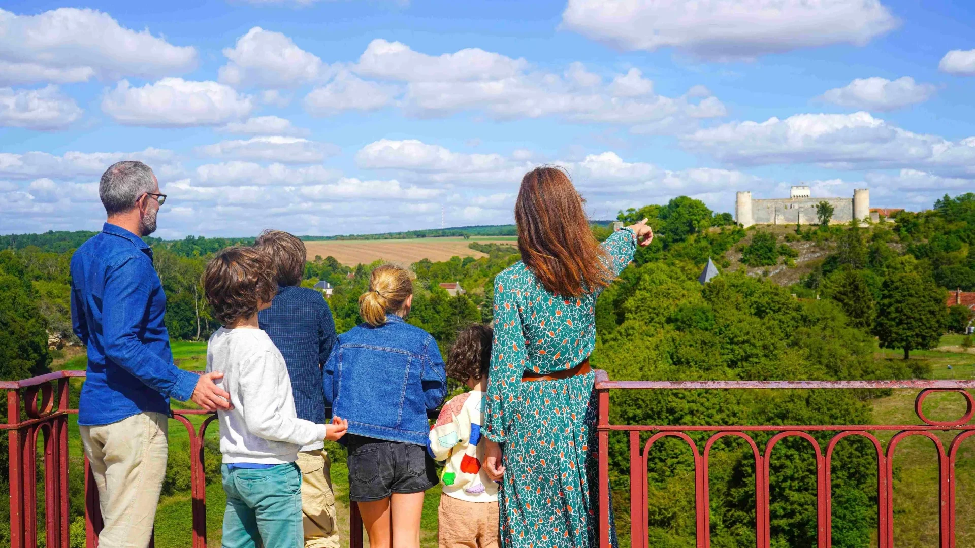 The view of the Château de Druyes-les-Belles-Fontaines from the viaduct for a family of vacationers