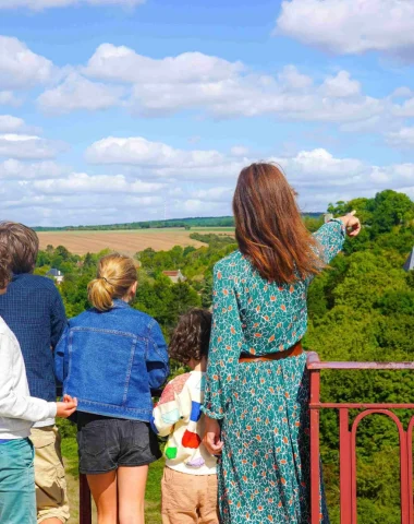 The view of the Château de Druyes-les-Belles-Fontaines from the viaduct for a family of vacationers