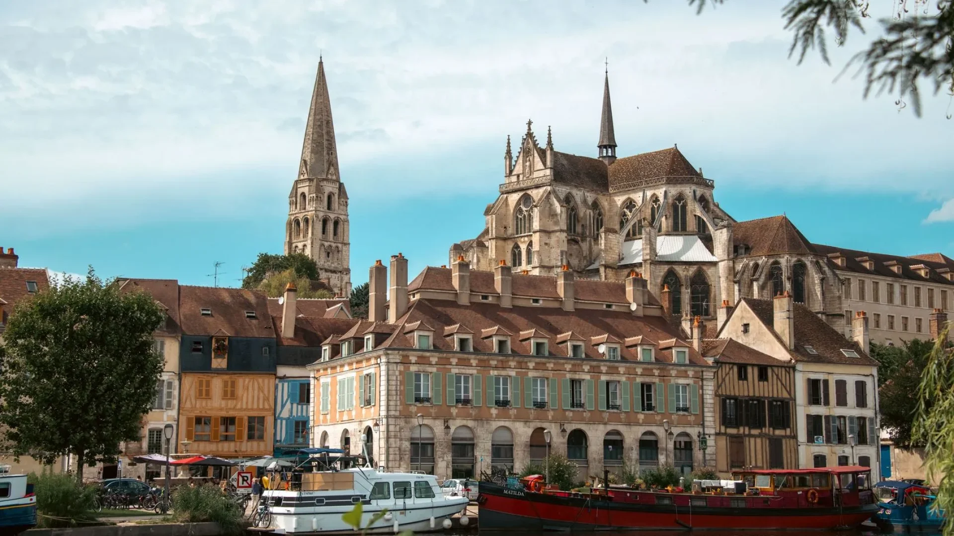 Vue sur l'Abbaye Saint-Germain depuis les quais avec les péniches et les maisons à pan de bois