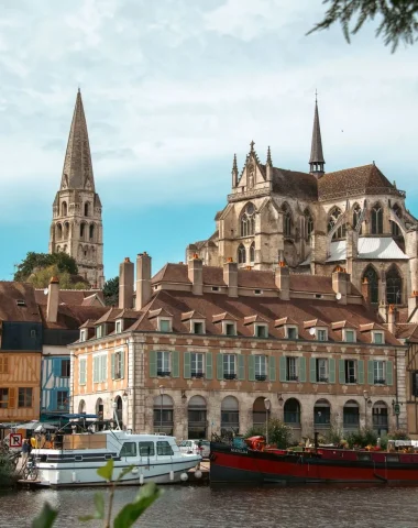 View of Saint-Germain Abbey from the quays with barges and timber-framed houses